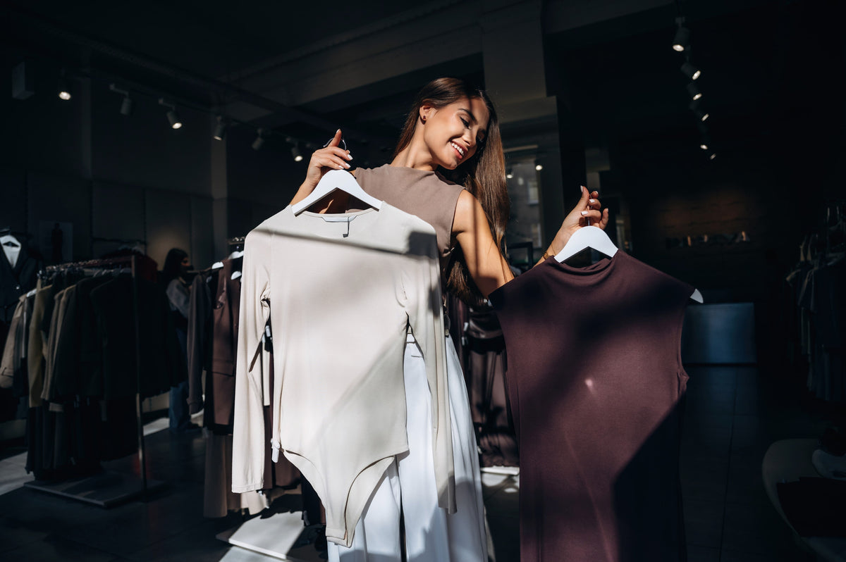 Woman shopping and comparing clothing options in boutique store